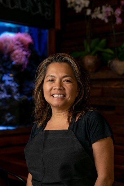 female chef smiling fish tank orchids